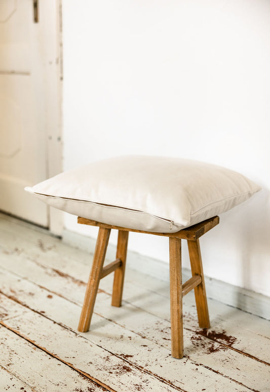 Kissen in Soft White aus Premium-Samt, seitliche Ansicht auf Hocker, handgefertigt