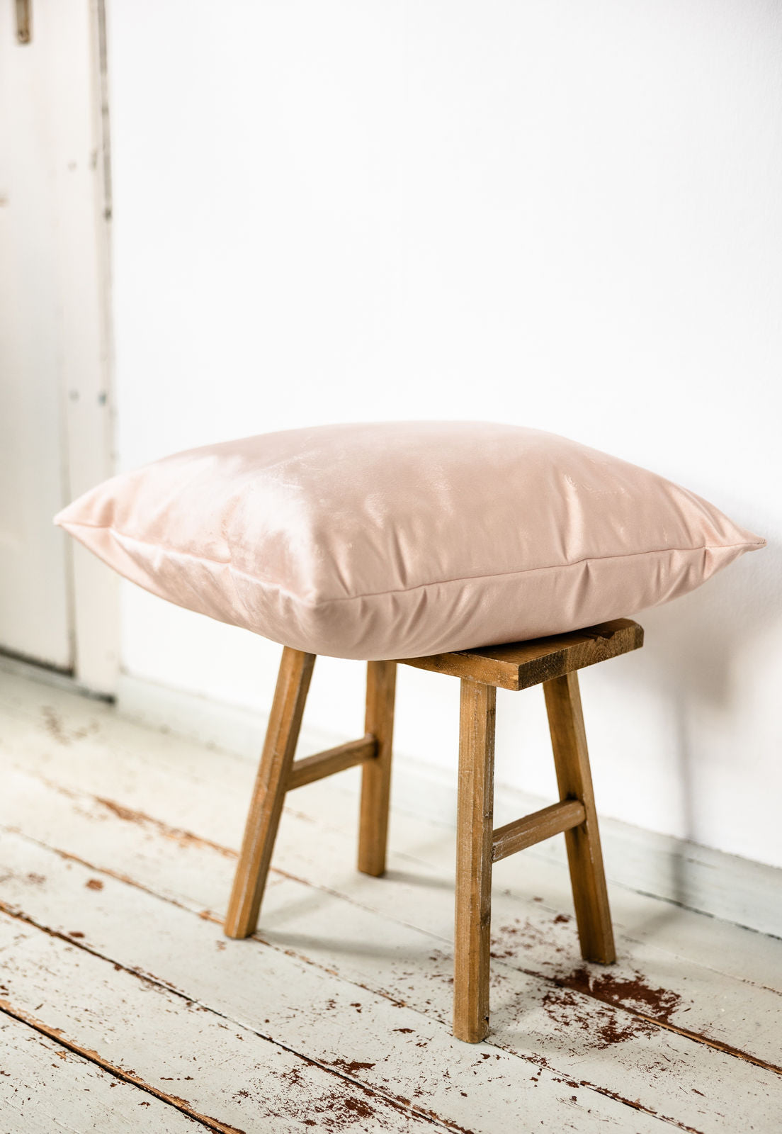 Rosa Samtkissen in Seitenansicht auf einem kleinen Hocker – edel schimmernder Stoff mit zartem Glanz, beidseitig aus Premium-Samt gefertigt.