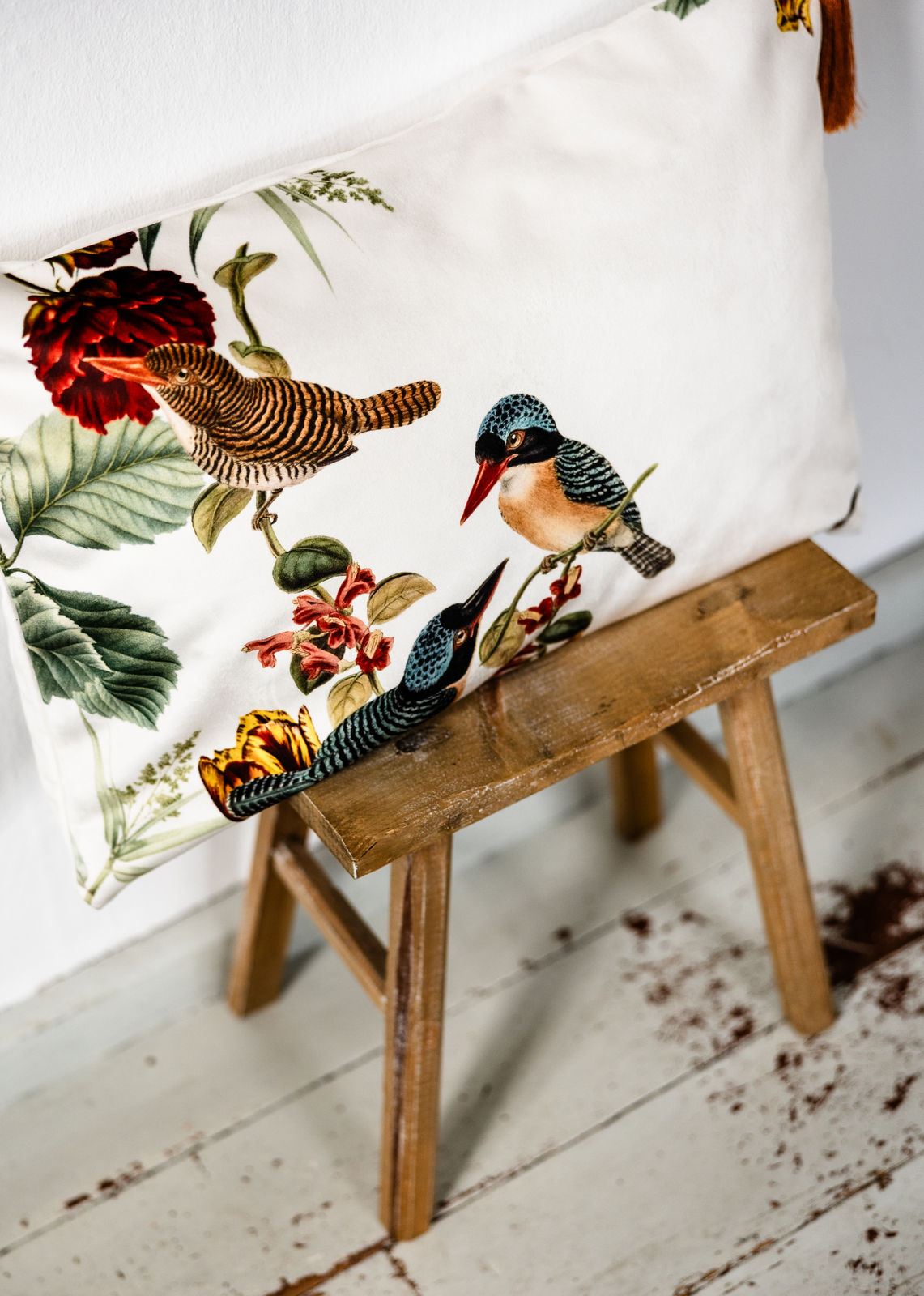 Premium Samt Dekokissen 40x60 cm mit detailliertem Vogel- und Blütendruck auf heller Vorderseite, auf Hocker platziert