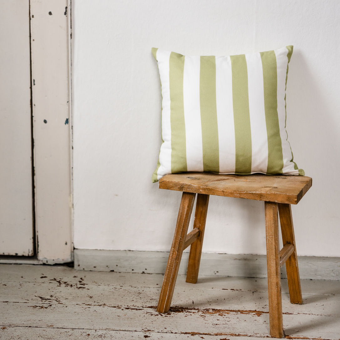 Grün-weiß gestreiftes Dekokissen auf Holzstuhl vor weißer Wand, Landhausstil, Outdoor geeignet
